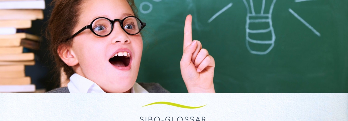 Mädchen das vor einer Schultafel den Finger hebt